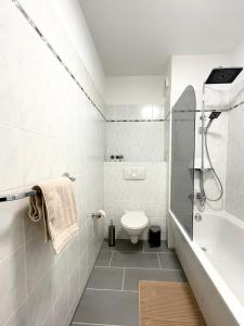 a white bathroom with a toilet and a shower at Parkside City Apartment - Leipzig Zentrum - Netflix in Leipzig