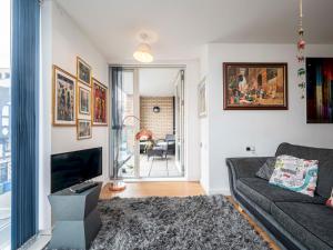 uma sala de estar com um sofá e uma televisão em London Apartment near Tower Bridge and Tube Pass the Keys em Londres