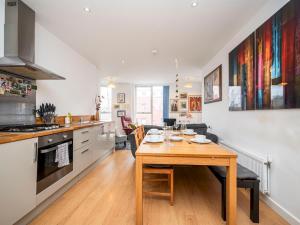 uma cozinha e sala de estar com uma mesa de madeira em London Apartment near Tower Bridge and Tube Pass the Keys em Londres