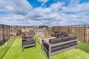 a patio with chairs and tables on the grass at Luxe Newark Retreat with Rooftop Deck Pets Welcome! in Newark