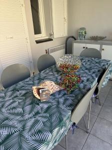 mesa de comedor con edredón azul y blanco en HOLIDAYLAND 432 VILLA T2 MEZZANINE 6 couchages climatisé avec véranda et Box internet NARBONNE PLAGE, en Narbonne-Plage