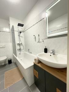 a bathroom with a sink and a tub and a mirror at Parkside City Apartment - Leipzig Zentrum - Netflix in Leipzig