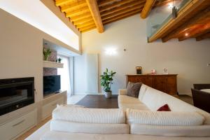 ein Wohnzimmer mit einem weißen Sofa und einem TV in der Unterkunft Appartamento Stella - Verona Centro in Verona