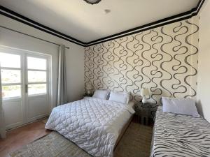um quarto com uma cama e um mural de parede em Banana Surf House em Tamri