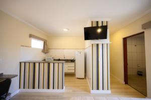 a kitchen with a counter and a refrigerator in a room at Colonial Flat Hotel in Itapetininga