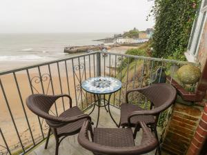 テンビーにあるApartment 4の椅子とテーブルと海のあるバルコニー