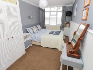 テンビーにあるApartment 4のベッドと椅子のある小さな寝室