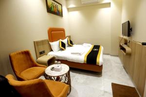 Habitación de hotel con cama, TV y sillas en Hotel A R Paradise en Mire