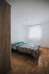 a bedroom with a bed and a wooden floor at Apartment Peckham in Trebinje