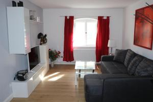sala de estar con sofá y cortinas rojas en Zur alten Schmiede en Ettal