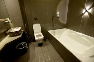 a bathroom with a sink and a toilet and a tub at Hotel A R Paradise in Mire