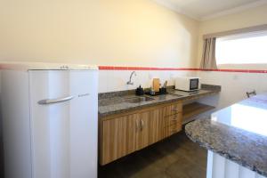 a kitchen with a refrigerator and a sink at Colonial Flat Hotel in Itapetininga