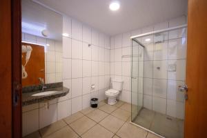 a bathroom with a glass shower and a toilet at Colonial Flat Hotel in Itapetininga