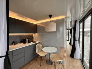 a kitchen with a table and two chairs and a counter at Escale Royale Saint Jean de Losne 35' de Dijon House Boat sur l'eau in Saint-Jean-de-Losne