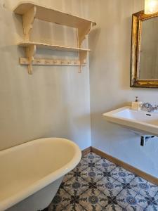 La salle de bains est pourvue d'une baignoire et d'un lavabo. dans l'établissement Logeerderij tussen Koe & Kroonluchter, à Diessen