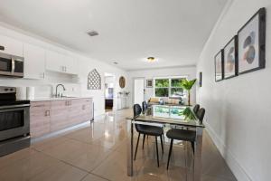 a kitchen and dining room with a table and chairs at Amazing 3 Bed House With Heated Pool and Outdoor Jacuzzi in North Miami Beach