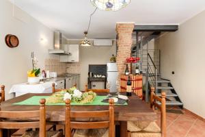 Il comprend une cuisine et une salle à manger avec une table et des chaises en bois. dans l'établissement Cascina Cavallo, à Canale