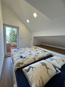 a large bed in a room with a window at Špan Cottage in Jesenice