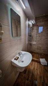 La salle de bains est pourvue d'un lavabo blanc et d'un miroir. dans l'établissement Santa Fe, à Suceava