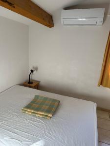 um quarto com uma cama com uma almofada em HOLIDAYLAND 420 VILLA T3 MEZZANINE 8 couchages climatisé NARBONNE PLAGE em Narbonne Plage