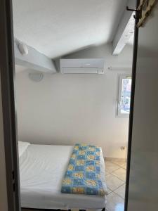 a small room with a bed and a window at HOLIDAYLAND 401 VILLA T3 MEZZANINE 7 couchages climatisé NARBONNE PLAGE in Narbonne-Plage