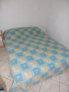 a bed in a room with a blue and orange bedspread at HOLIDAYLAND 401 VILLA T3 MEZZANINE 7 couchages climatisé NARBONNE PLAGE in Narbonne-Plage