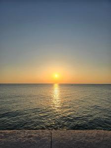 einen Sonnenuntergang über dem Meer mit Sonnenuntergang in der Unterkunft Palazzo Scianni in Monopoli