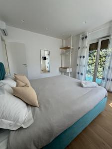 un grande letto in una camera bianca con finestre di Casa Vacanze Imma a Sorrento