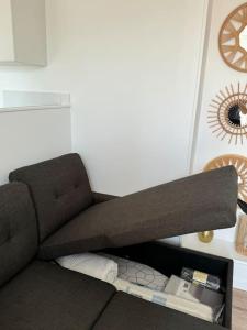 a brown couch in a room with a clock on the wall at Appartement aux portes de Paris in Ivry-sur-Seine +22 photos