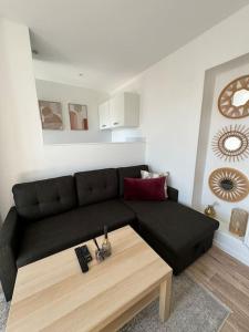 a living room with a black couch and a coffee table at Appartement aux portes de Paris in Ivry-sur-Seine