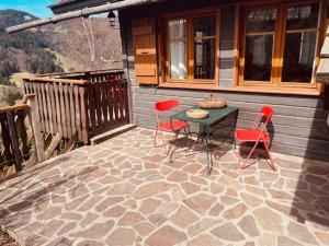 a patio with a table and chairs on a house at LA GODILLE in La Clusaz