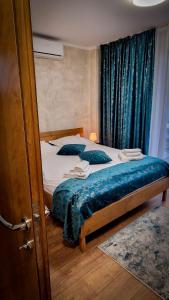 sypialnia z łóżkiem z niebieską pościelą i poduszkami w obiekcie Santa Fe w Suczawie