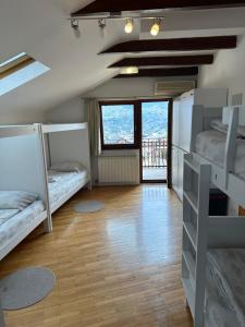 a room with two bunk beds and a hallway with windows at One Love in Sarajevo