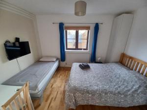 a bedroom with two beds and a window at Guest house with en-suite rooms and free parking in London