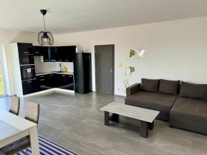 sala de estar con sofá, mesa y cocina en Byt apartman 74m2 vyhled klid priroda en Praga