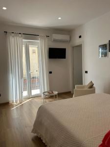 a bedroom with a bed and a chair and window at B&B Terzo Piano in Cava deʼ Tirreni