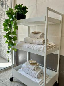 - une pile de serviettes sur une étagère dans une salle de bains dans l'établissement B&B Terzo Piano, à Cava deʼ Tirreni