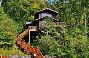 eine Hütte im Wald mit einer Treppe, die dorthin führt in der Unterkunft Chalets Alpins - 15 Chemin Alpin in Stoneham