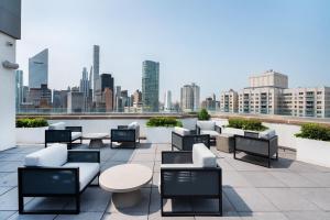 a rooftop patio with tables and chairs and a city skyline at Luxurious 2 BR Apartment in New York in New York