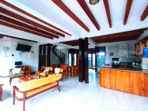 a kitchen and living room with a couch and chairs at Hostal GalaHouse in Puerto Ayora