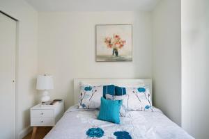 a bedroom with a bed with blue and white pillows at Luxurious 2 BR Apartment in New York in New York