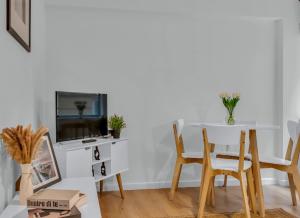 a living room with a table and chairs and a tv at Mansion House Flat by MySquare in London