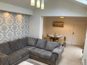 a living room with a couch and a table at Guest Homes - Hunters Wood Court in Euxton