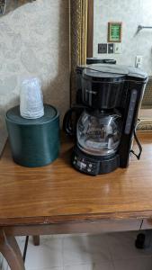 a coffee maker sitting on a wooden table next to a container at Edelweiss Inn New Braunfels in New Braunfels