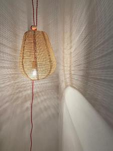 una luz colgando de una pared blanca con una cuerda en Casa Prada en Sanabria, en Sotillo de Sanabria