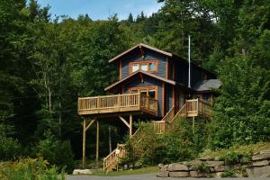 a log cabin in the woods with a balcony at Chalets Alpins- 19 Chemin Alpin in Stoneham