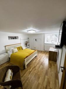 a bedroom with a bed with a yellow blanket at The Danes Gower, Llanmadoc, Gower in Swansea
