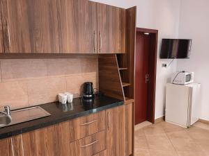 a kitchen with wooden cabinets and a white refrigerator at Sky Suites Osu in Accra