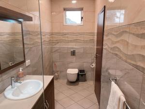 uma casa de banho com um lavatório, um WC e um chuveiro em Sky Suites Osu em Acra