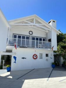 a white house with a balcony on the side of it at The Joneses in Plettenberg Bay